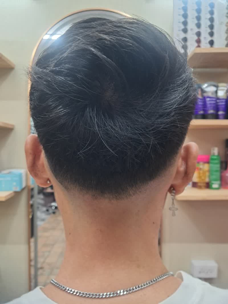 Dark hair in a taper fade, back view