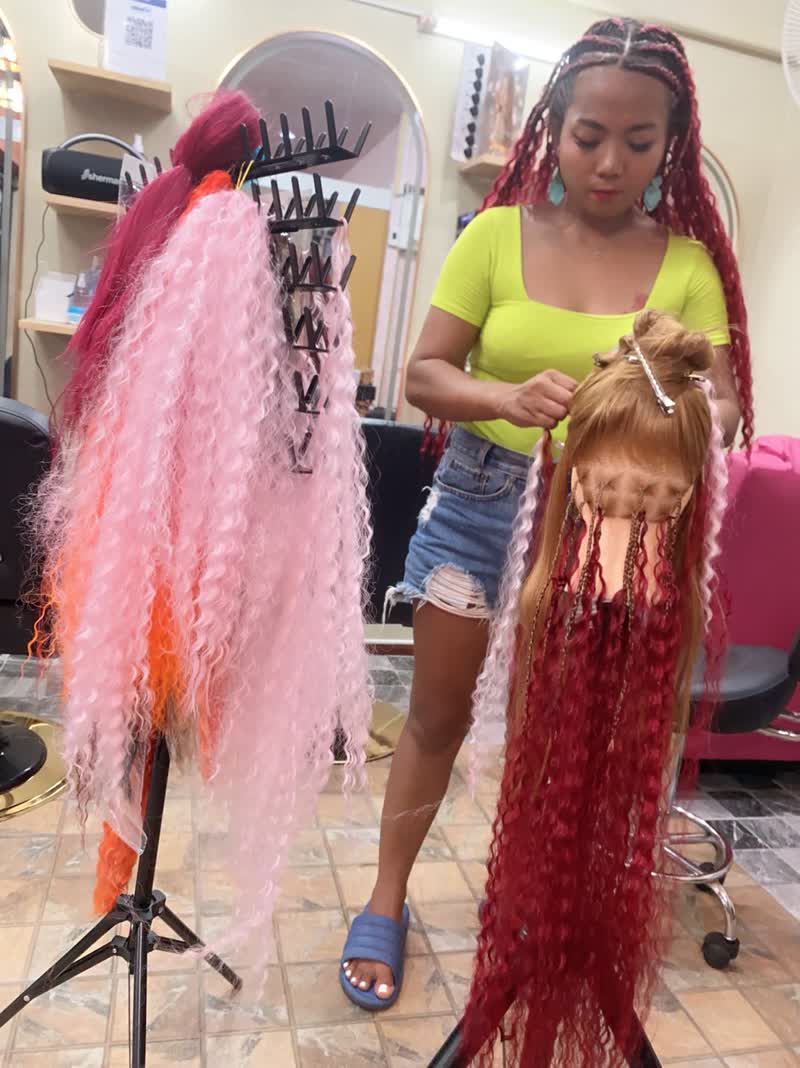 Braiding long red extensions in the salon
