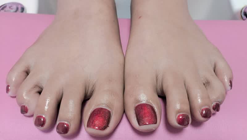 Pedicure with glossy metallic red toenails