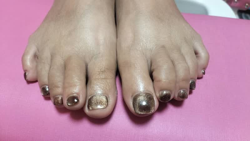 Fresh pedicure with glittery bronze gold polish