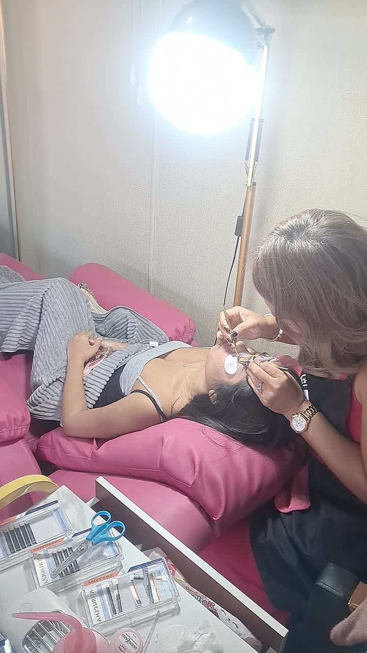 Eyelash extensions being applied with tweezers