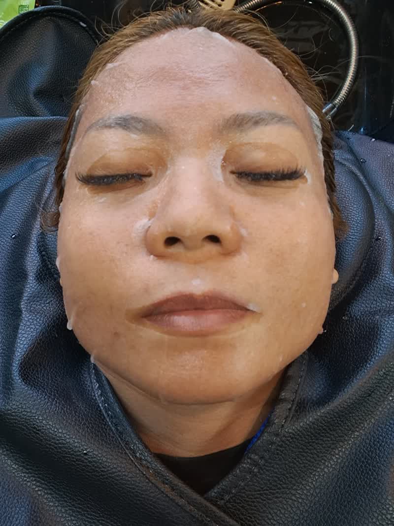 Client relaxing during a white cream facial mask