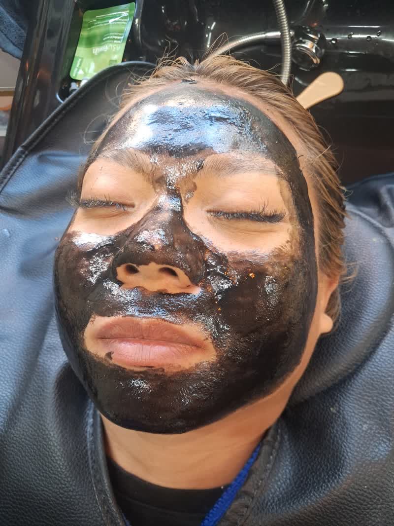 Charcoal peel-off mask during a facial treatment